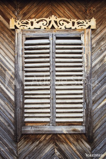 Picture of The old weathered wooden closed window with hinges and carved shutters Retro